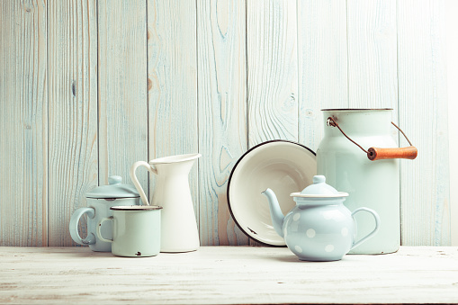 Enamelware on the kitchen table over blue wooden wall