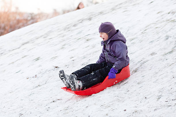 istock Child playing with sled in winter snow 503330430