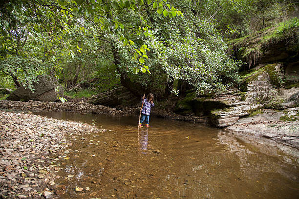 istock girl playing by river 503331740