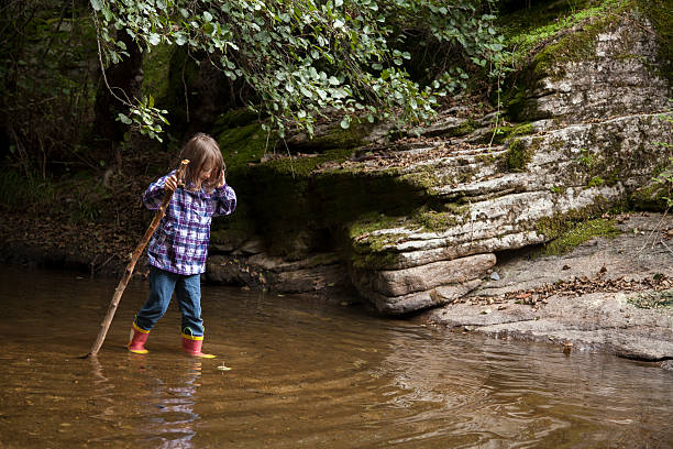 istock girl playing by river 503331918