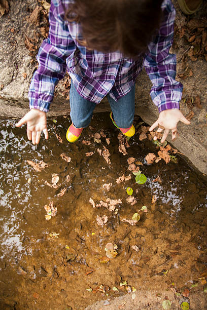 istock girl playing by river 503332604