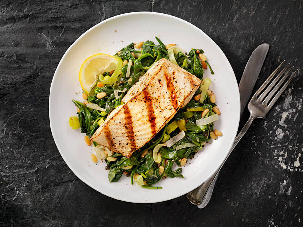 grilled halibut with spinach, leeks and pine nuts - bord serviesgoed fotos stockfoto's en -beelden