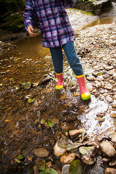 istock girl playing by river 503337630