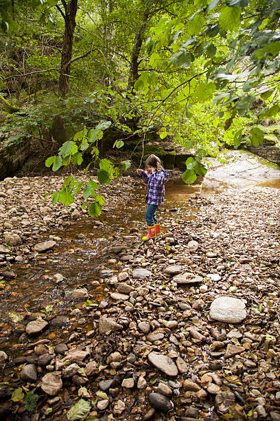 istock girl playing by river 503337972
