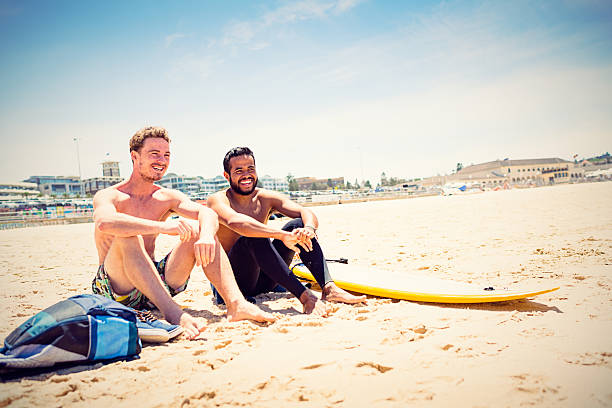 Mixed race friends with surfboard at Bondi Beach, Australia