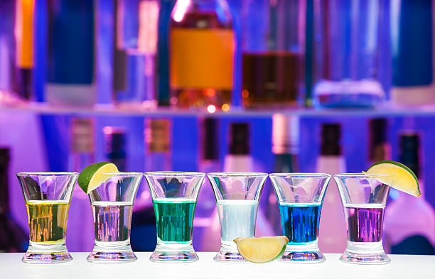 istock Shot glasses with lime in row, bar bottles on back 503338694