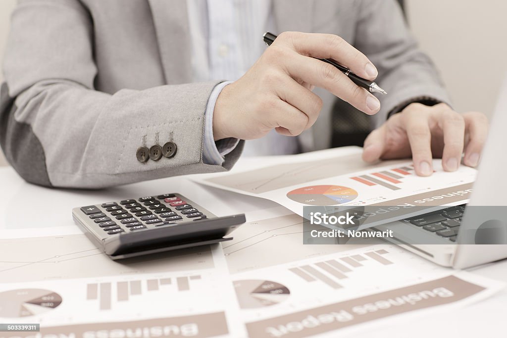 Businessman analyzing investment charts with laptop. Accounting Adult Stock Photo