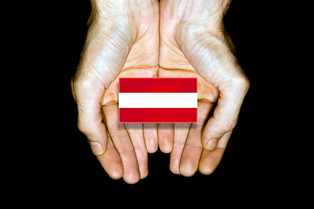 Flag of Austria in hands isolated on black background.