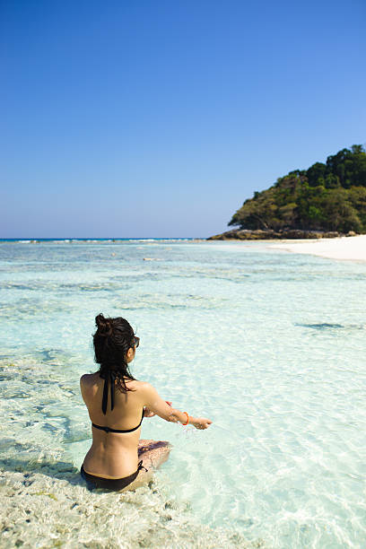 istock Bikini girl relaxing in clear water on tropical beach 503342333