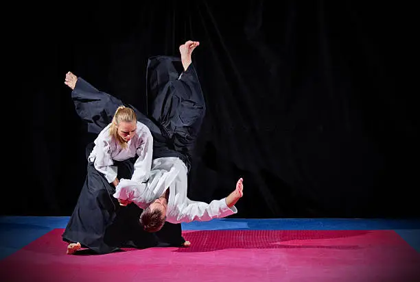 Fight between two aikido fighters on black