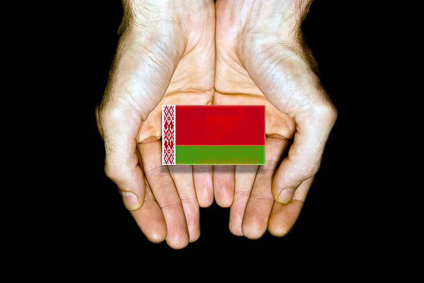 Flag of Belarus in hands isolated on black background.