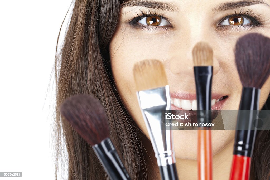 Face behind brushes Close-up of female face with cosmetic brushes in front Adult Stock Photo