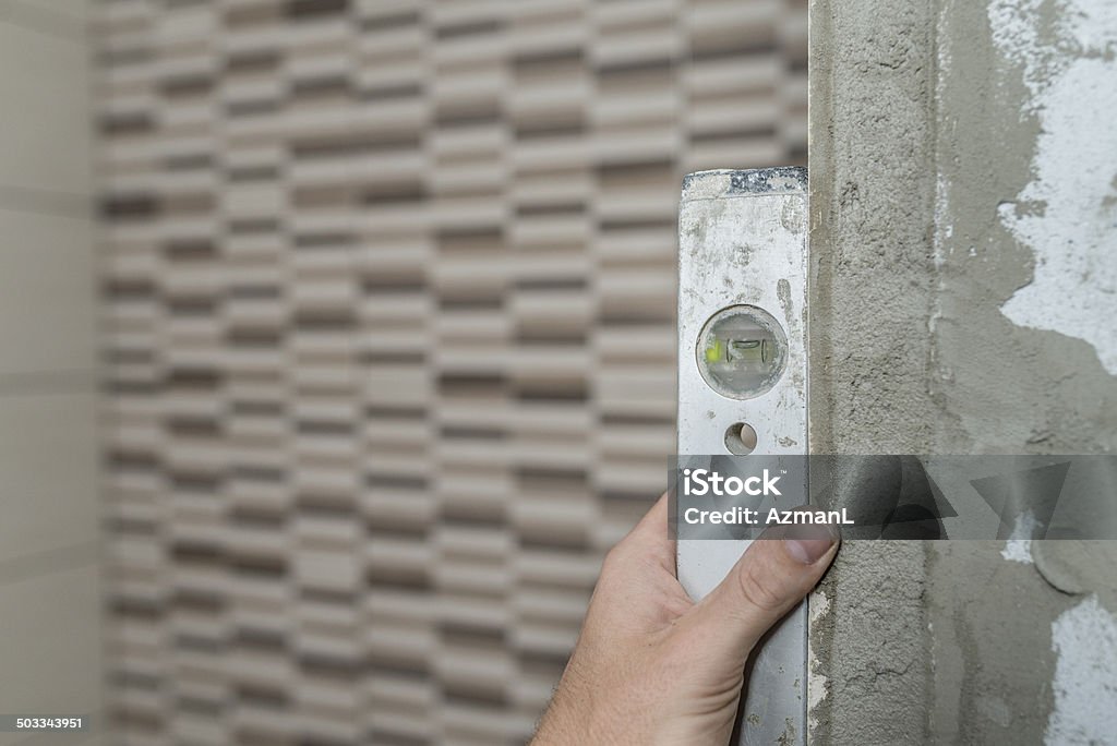 Checking level Checking alignment of new tiles with level. DIY Stock Photo