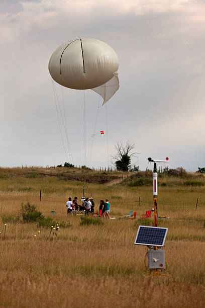 Meteorological station and weather balloon science team Colorado Golden, Colorado, USA - July 26, 2014: A solar powered meteorological station stands in front of a Millersville University science team which prepares a large weather balloon with numerous sensitive pollution measuring instruments. weather balloon stock pictures, royalty-free photos & images