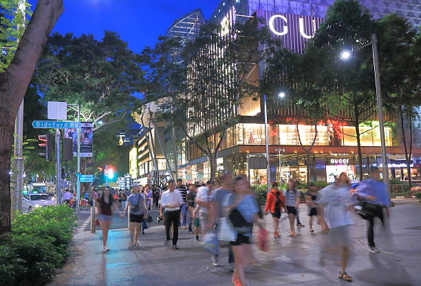 Singapore, Singapore - 26 May, 2014: Tourists and local people walk busy Orchard Road Singapore by night.