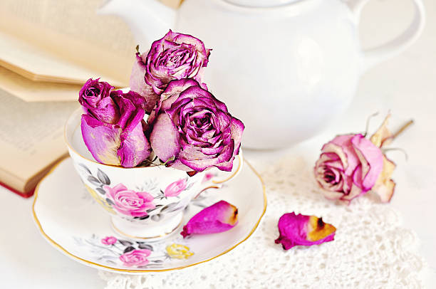 istock Vintage tea cup with dry roses on white background 503352418