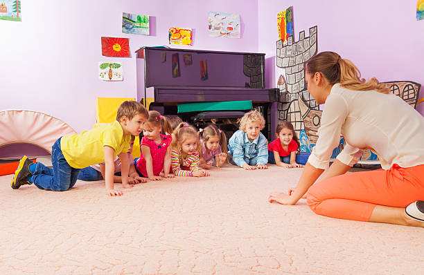 istock Active game kids and teacher stand on all fours 503353122