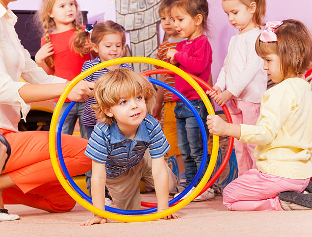 istock Nice boy play with hoops in kindergarten goup 503353744