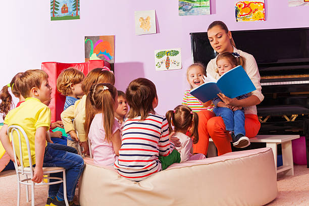 istock Nurse in kindergarten read book to the class 503354278