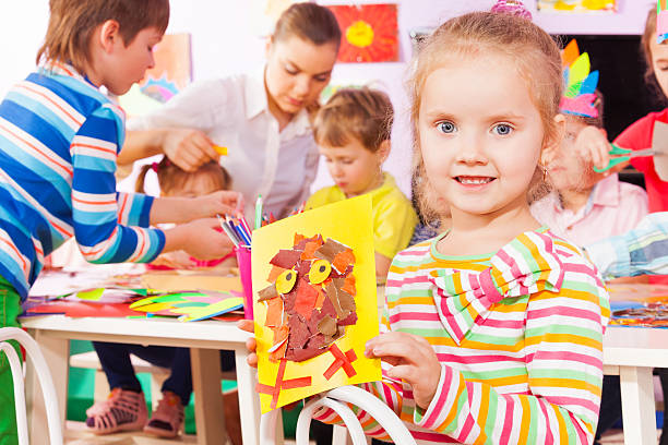 istock Girl hold picture and kindergarten class on back 503355056