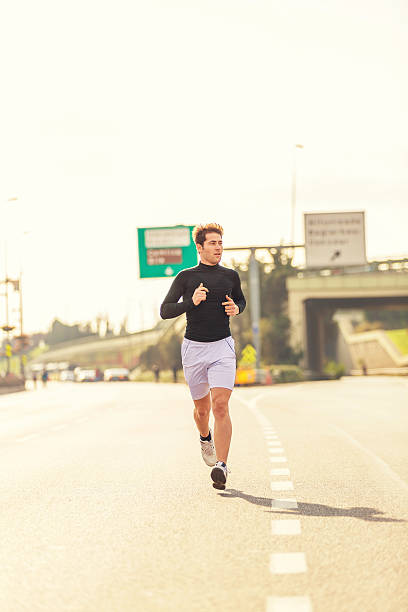 istock Young male athlete running on road 503355378