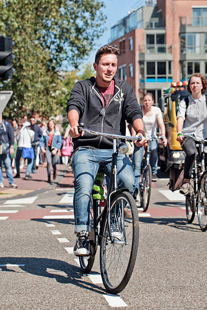 ein gut aussehender junger mann, radfahren in sonnigen amsterdam - editorial outdoors vertical amsterdam stock-fotos und bilder