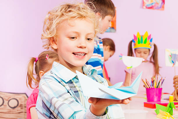 istock Blond handsome boy shows origami 503359744