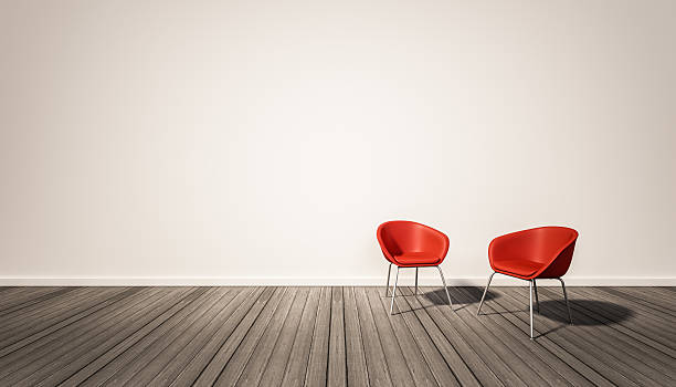 white wall and dark wood floor, with red chairs