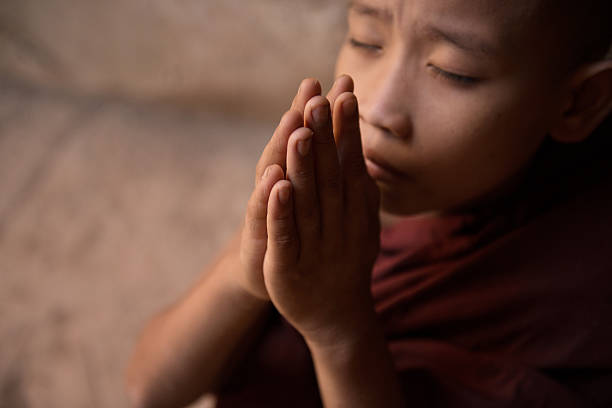 istock Close up Buddhist novice monks praying 503362560