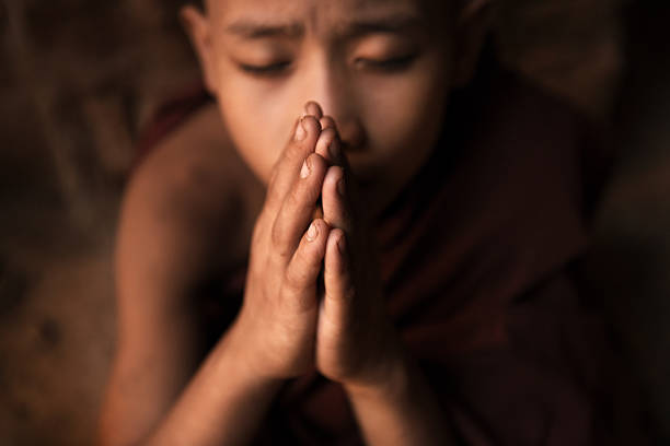 istock Buddhist novice monks praying in temple 503362574