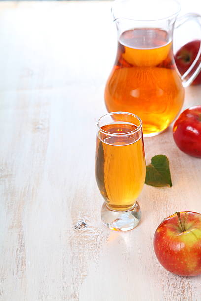 istock Apple juice and apples on a  wooden table 503364070