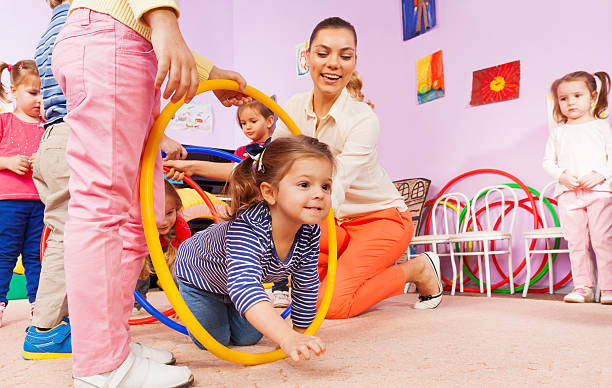 istock Kids crawl though hoop with teacher and friends 503365552