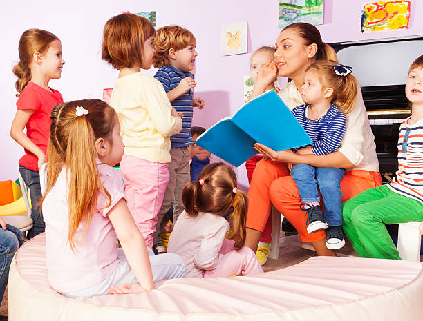 istock Teacher with kids read and discuss book 503365968
