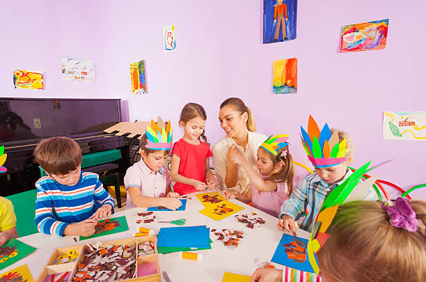istock Teacher helps kids glue craft images 503366352