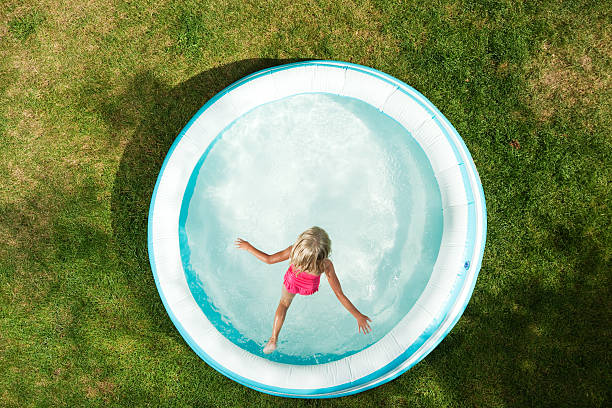 menina pulando na piscina insuflável, verão em capim seco - above ground pool - fotografias e filmes do acervo