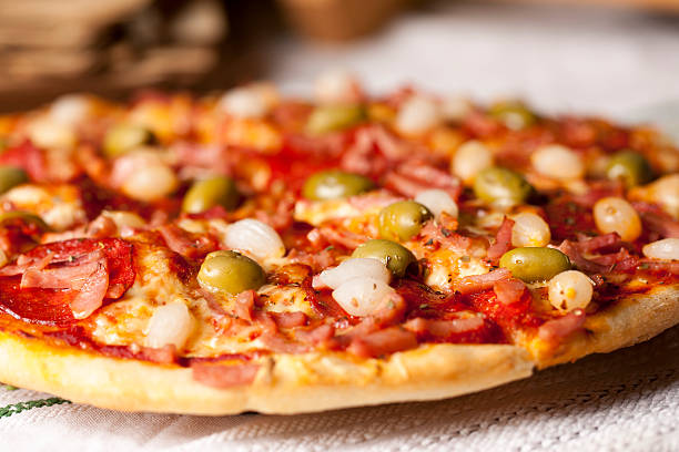 Pizza with ham, salami, olive, bacon, onion