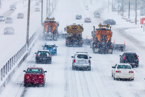 Tree Lined-up Snowplows Removing the Swno the Highway on a Cold Snowy Winter Day