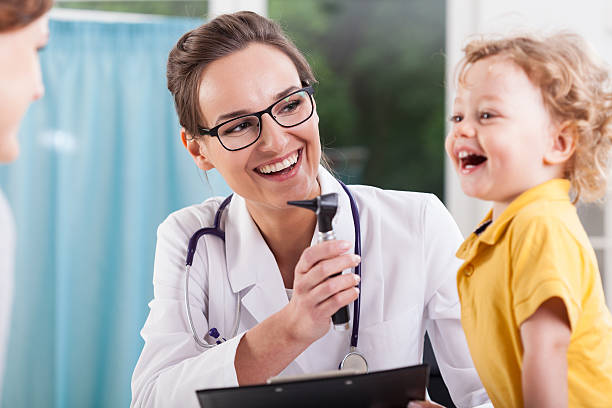 Happy boy after health exam at doctor's office Happy little boy after health exam at doctor's office nurse smock stock pictures, royalty-free photos & images