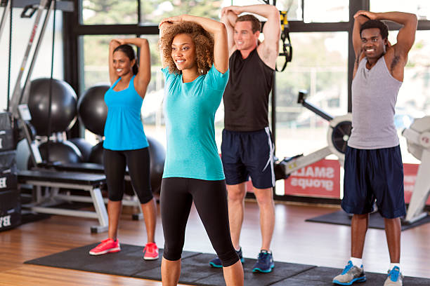 Multi-ethnic group stretching in a gym stock photo