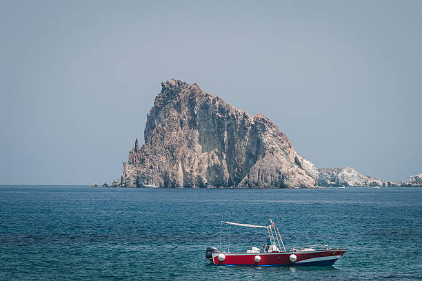 Volcanic island outcrop as seen from Panarea, Sicily. Panarea (Sicily), Italy - 10 July 2012:  Volcanic outcrop juts out of the Mediterranean Sea and forms part of the Aeolian Island complex in southern Italy. panarea island stock pictures, royalty-free photos & images