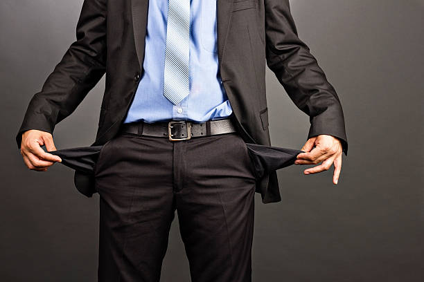 Business man showing his empty pockets Business man showing his empty pockets  on gray background poverty stock pictures, royalty-free photos & images