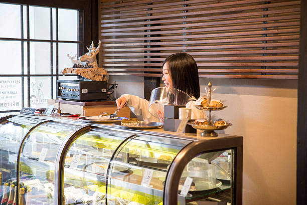 jovem bonita empregada de mesa no café restrant japonês em tóquio - coffee serving cafeteria worker checkout counter imagens e fotografias de stock