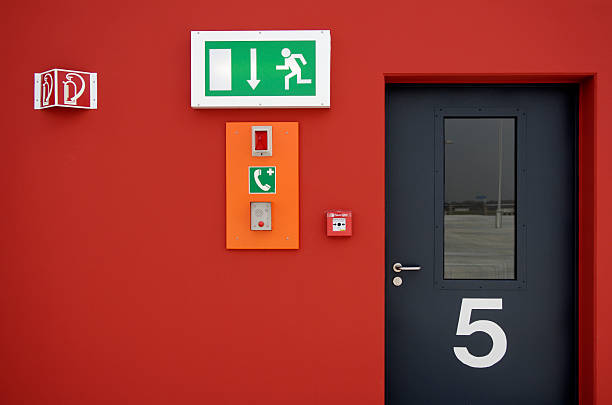 аварийный выход знак и пожарная сигнализация» и черный дверь - exit button стоковые фото и изображения