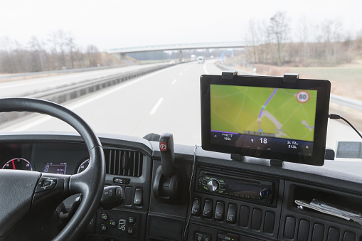 Inside the cab of the truck while driving. Focused on the tablet with navigation. The map is intentionally slightly out of focus. All potential trademarks are removed