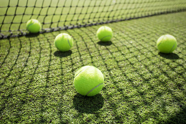 Tennis balls on the court grass Five tennis balls on the court grass wimbledon stock pictures, royalty-free photos & images