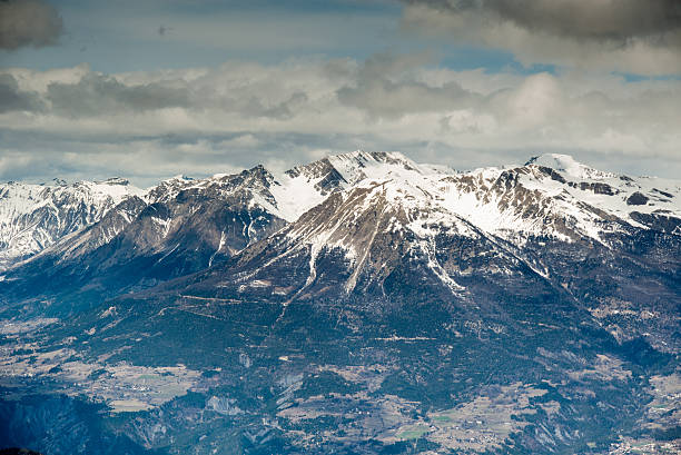 istock Top of snowy rock mountain on cloudy background 503393180