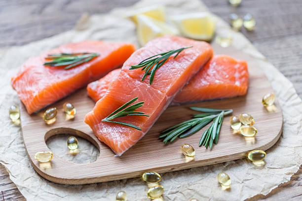 fonti di omega - 3 acido (salmone e l'omega - 3 pillola - healthy eating red colors healthcare and medicine foto e immagini stock