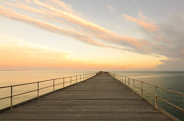 istock Wooden jetty at dusk with clouds in the sky 503396334