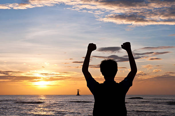 istock Successful man raising arms on the beach sunset 503400709
