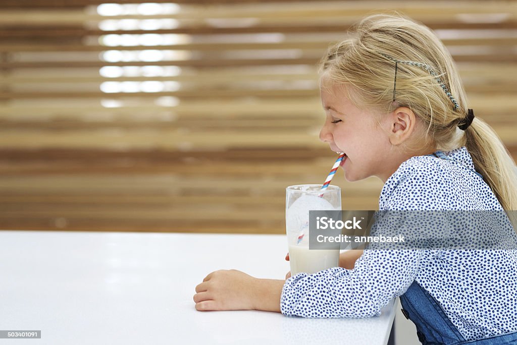 Settling down for a cold one after a long day Side view of a cute little girl enjoying a glass of milk Blond Hair Stock Photo